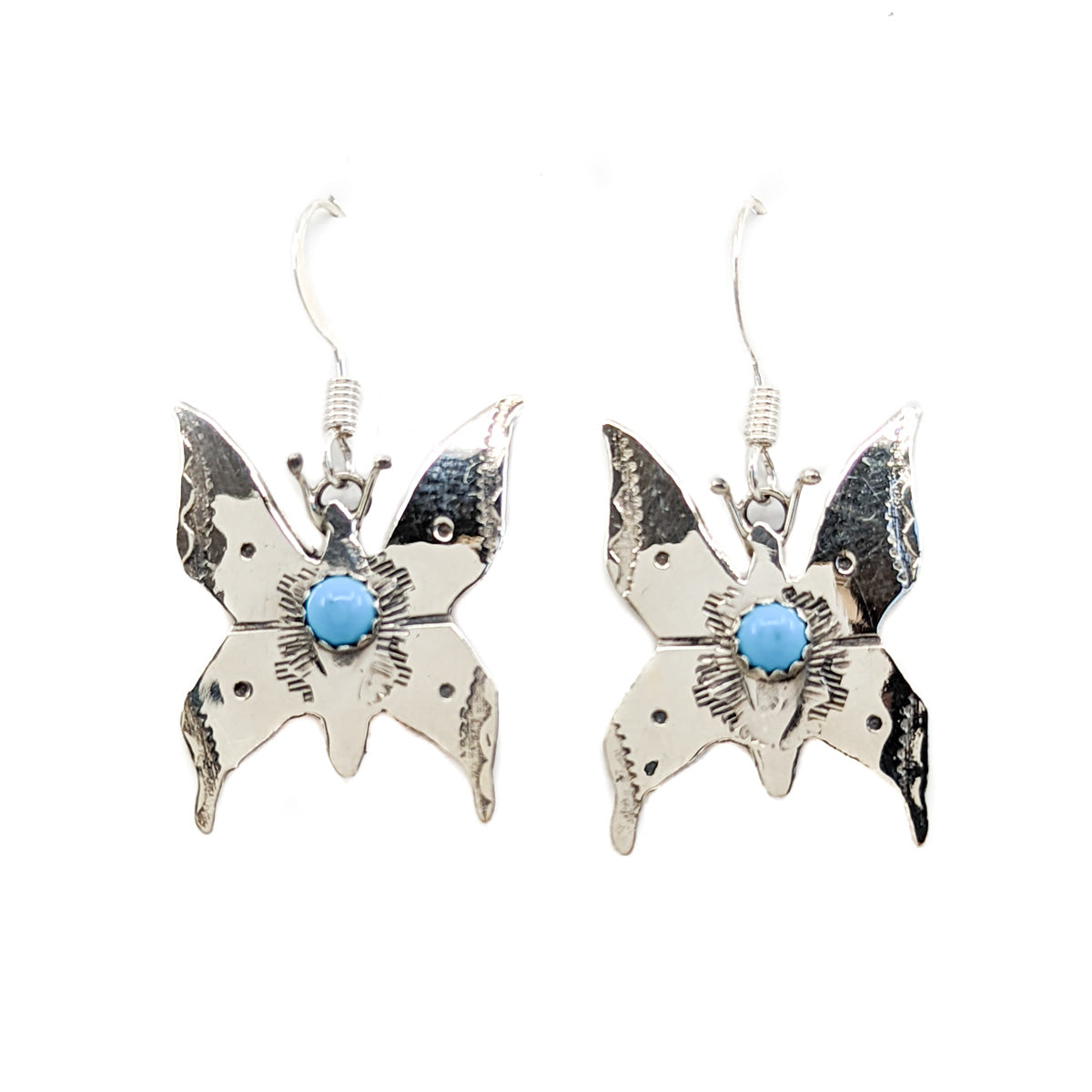 Sterling silver butterfly earrings with single turquoise stone and sterling silver wires These delicate earrings are hand stamped and measure approx. 1 inch x .75 inch, and dangle approx. .25 inches from earlobe By Diné silversmith Lucille Platero