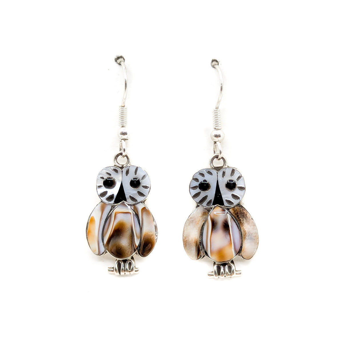 A pair of sterling silver owl-shaped earrings with shell inlay, measuring approximately 1 inch in length, dangling from earlobes.