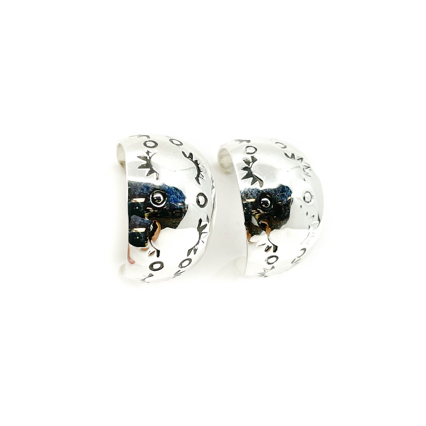 Handcrafted, sterling silver stamped hoop earrings (Diné)
Each earring tapers in shape and measures approx .25 inches wide at start and end, with the widest point in the middle measuring .50 inch
Sterling silver posts and backs