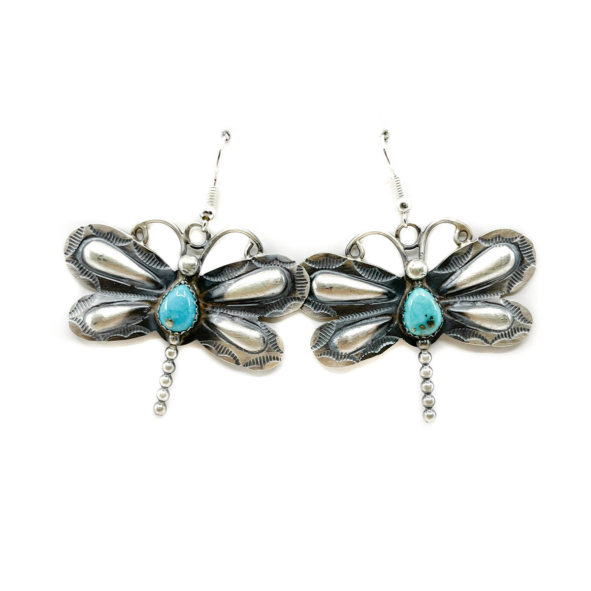 Handcrafted sterling silver and turquoise earrings by Diné artist Gabrielle Yazzie
Hand stamped with repousse work on French wires
Each earring measures 1.75 inches wide (wingspan) and dangle from ear approximately 2 inches in length
Turquoise cabochon measures approx. 3/8th of an inch long and 1/4 inch wide