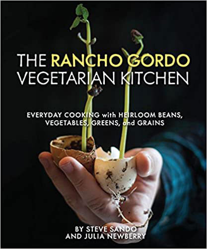 The Rancho Gordo Vegetarian Kitchen: Everyday Cooking with Heirloom Beans, Vegetables, Greens, and Grains by Steve Sando and Julia Newberry. Cover photo is a hand holding two sprouting plants